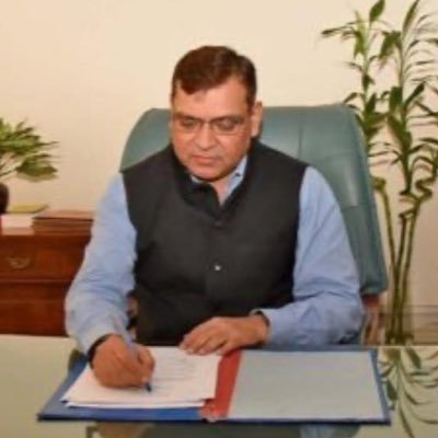Dhirendra Ojha signing official documents at his desk